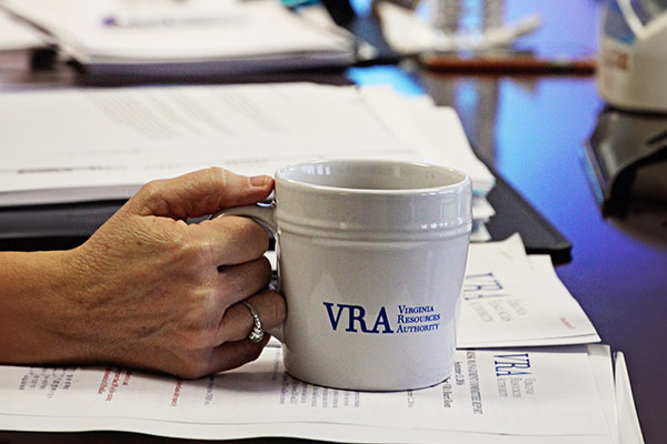 Woman's hand clasps a VRA mug during a meeting.