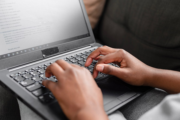 hands typing on laptop.