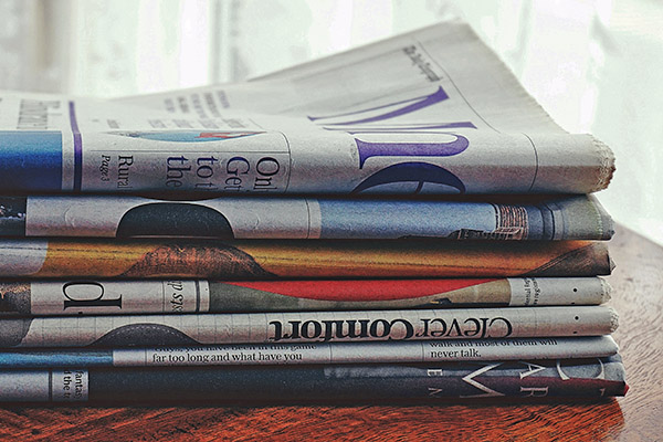 Stack of newspapers on table.