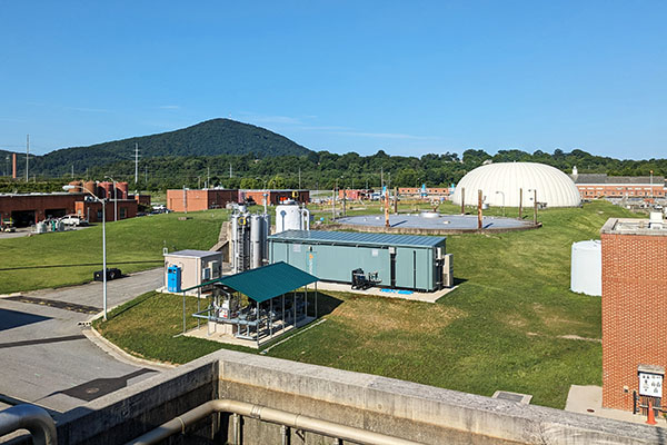 Water treatment facility with a green mountain in the background.